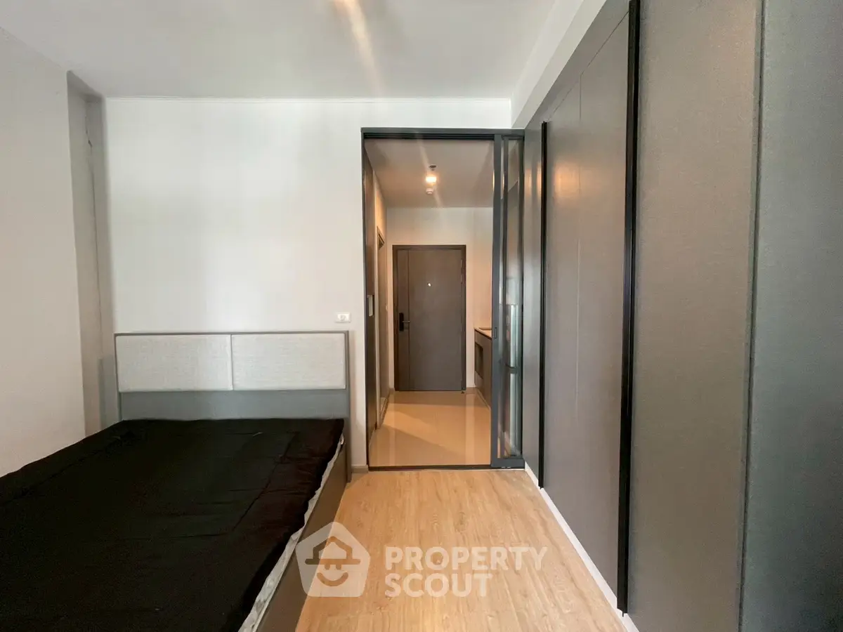 Modern bedroom with sleek design and wooden flooring in a contemporary apartment.