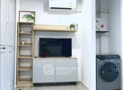 Modern living room with TV, air conditioner, and washing machine in compact space.