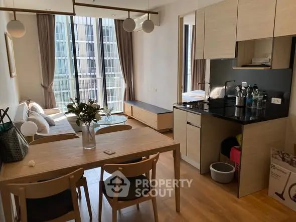 Modern open-plan living room and kitchen with natural light and stylish decor.