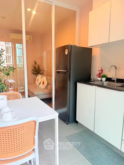 Modern kitchen with sleek appliances and cozy adjacent living area, perfect for urban living.