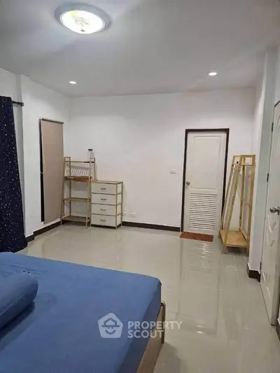 Spacious bedroom with minimalist furniture and tiled flooring