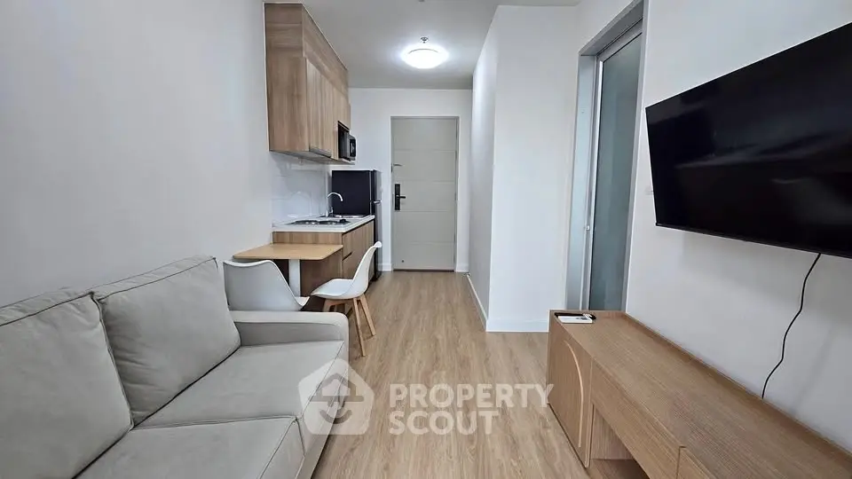 Modern compact living room with kitchenette and sleek furnishings