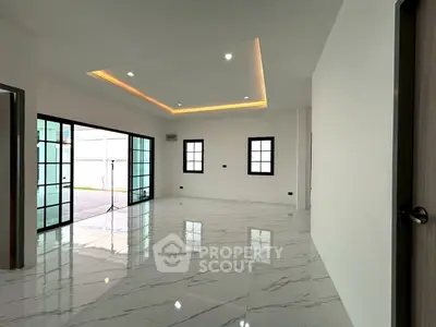 Spacious modern living room with marble flooring and recessed lighting