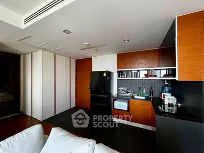 Modern kitchen with sleek cabinetry and black appliances in a stylish apartment.