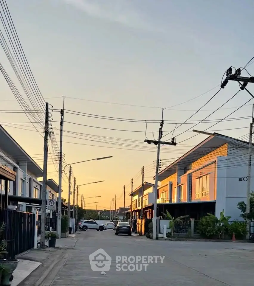 Charming suburban street with modern townhouses at sunset, showcasing serene residential living.