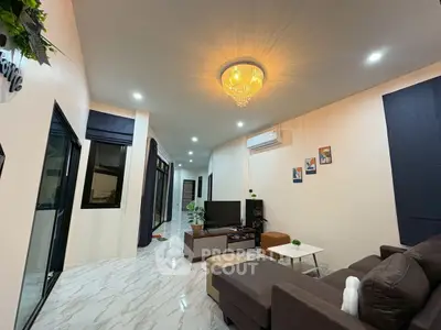 Spacious modern living room with elegant chandelier and cozy seating area