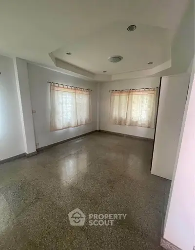 Spacious empty room with large windows and elegant ceiling design