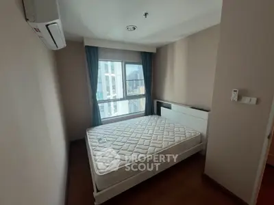 Cozy bedroom with large window and air conditioning in modern apartment