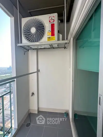 Compact balcony with air conditioning unit and city view, ideal for urban living.