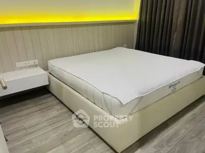Modern bedroom with stylish lighting and sleek wooden flooring