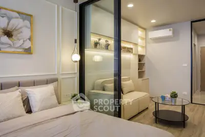 Modern bedroom with sliding glass partition and cozy living area, featuring elegant decor and ambient lighting.