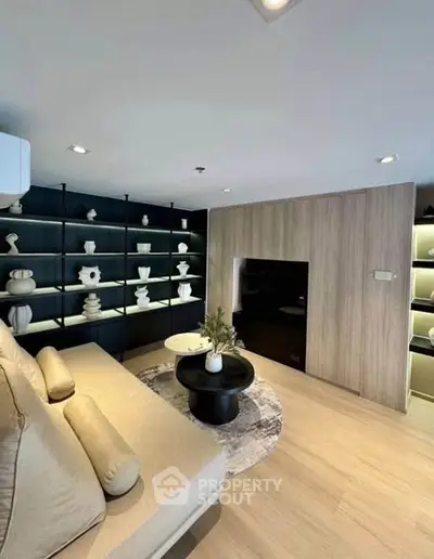 Modern living room with stylish decor and cozy seating area, featuring elegant shelving and contemporary design.