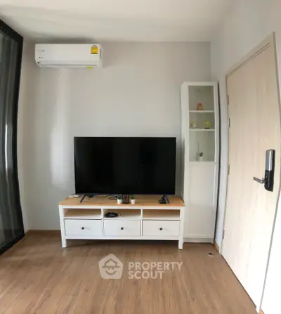 Modern living room with sleek TV setup and air conditioning unit