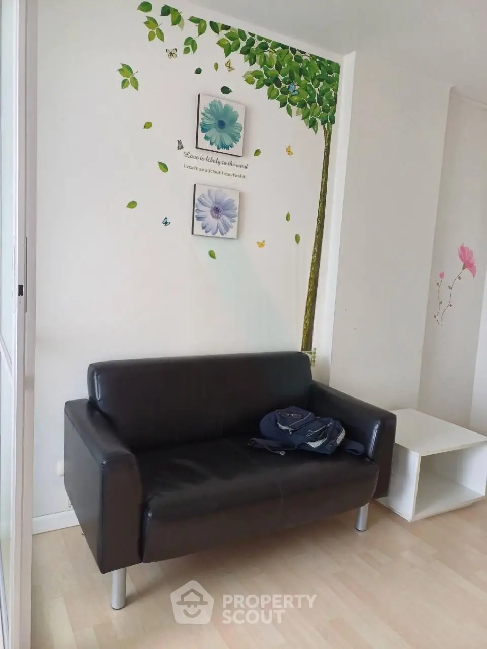 Charming living room with stylish black sofa and artistic wall decor, perfect for modern interiors.