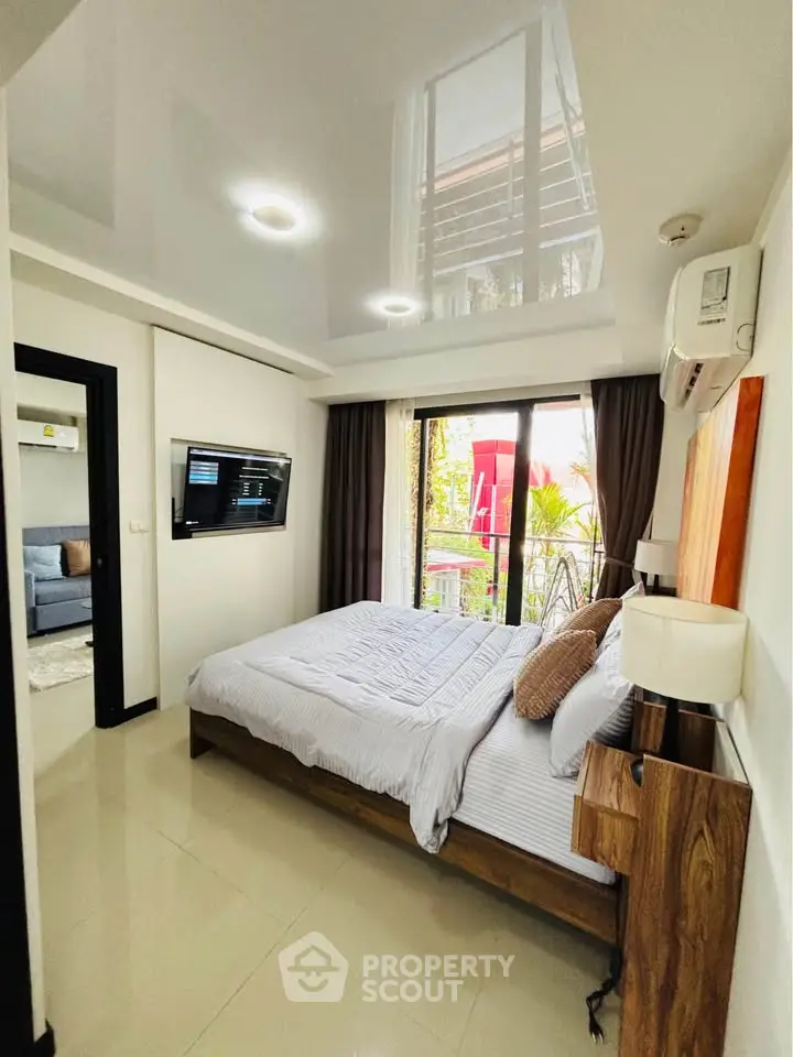 Modern bedroom with sleek design and balcony access in a stylish apartment.