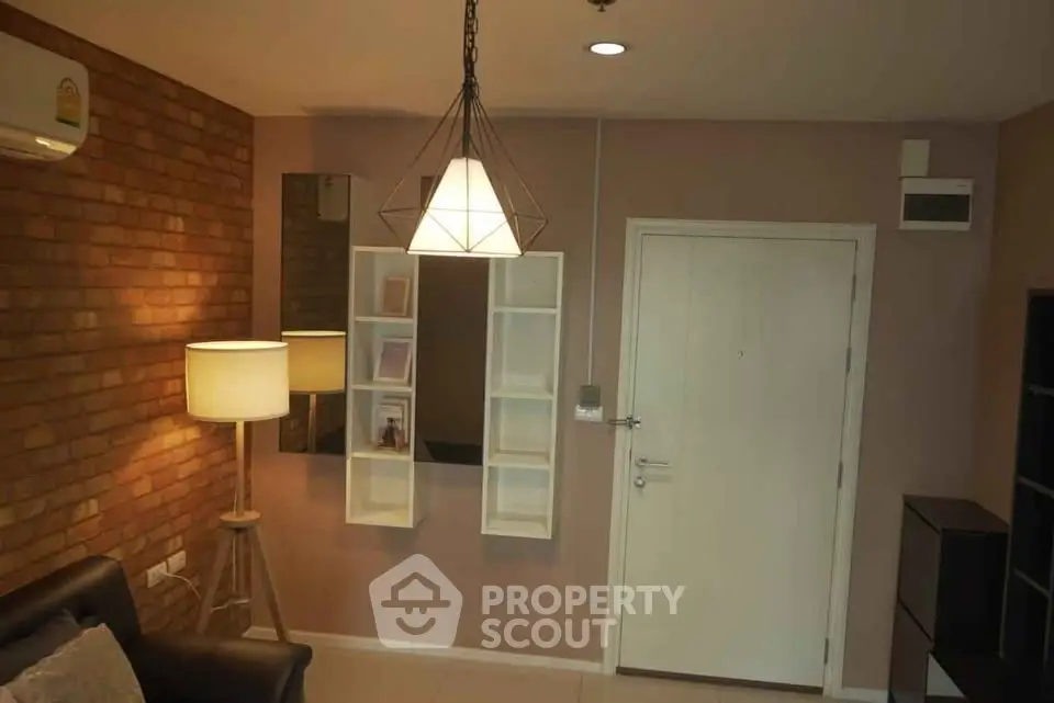 Stylish living room with modern lighting and brick accent wall, perfect for cozy evenings.