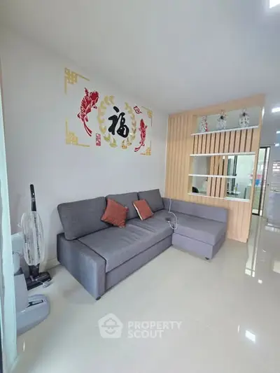 Modern living room with stylish sectional sofa and decorative wall art in a bright, spacious interior.