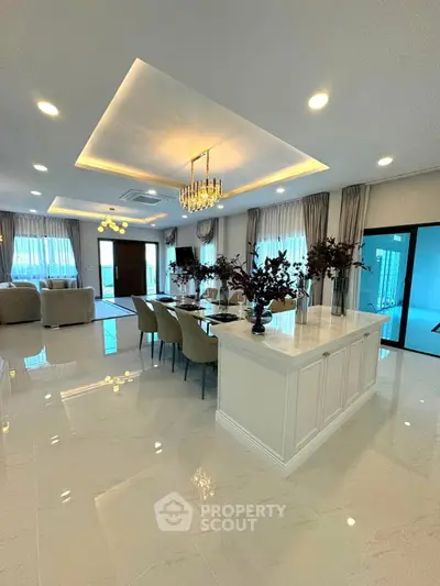 Luxurious open-plan living and dining area with elegant decor and modern lighting.