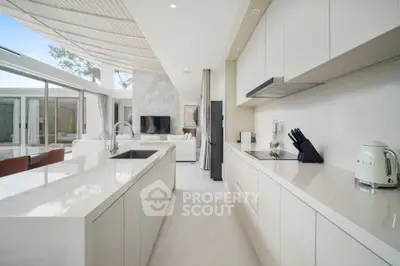 Luxurious modern kitchen with sleek white cabinetry and open layout in a bright, airy home.