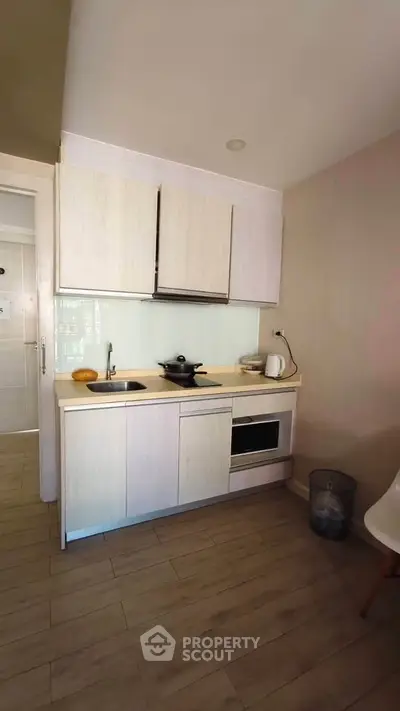 Compact modern kitchen with sleek cabinetry and built-in appliances