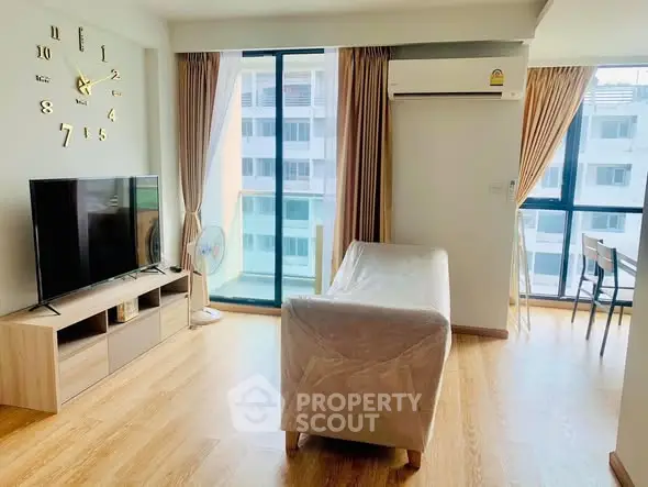 Spacious living room with modern decor and large windows offering natural light.