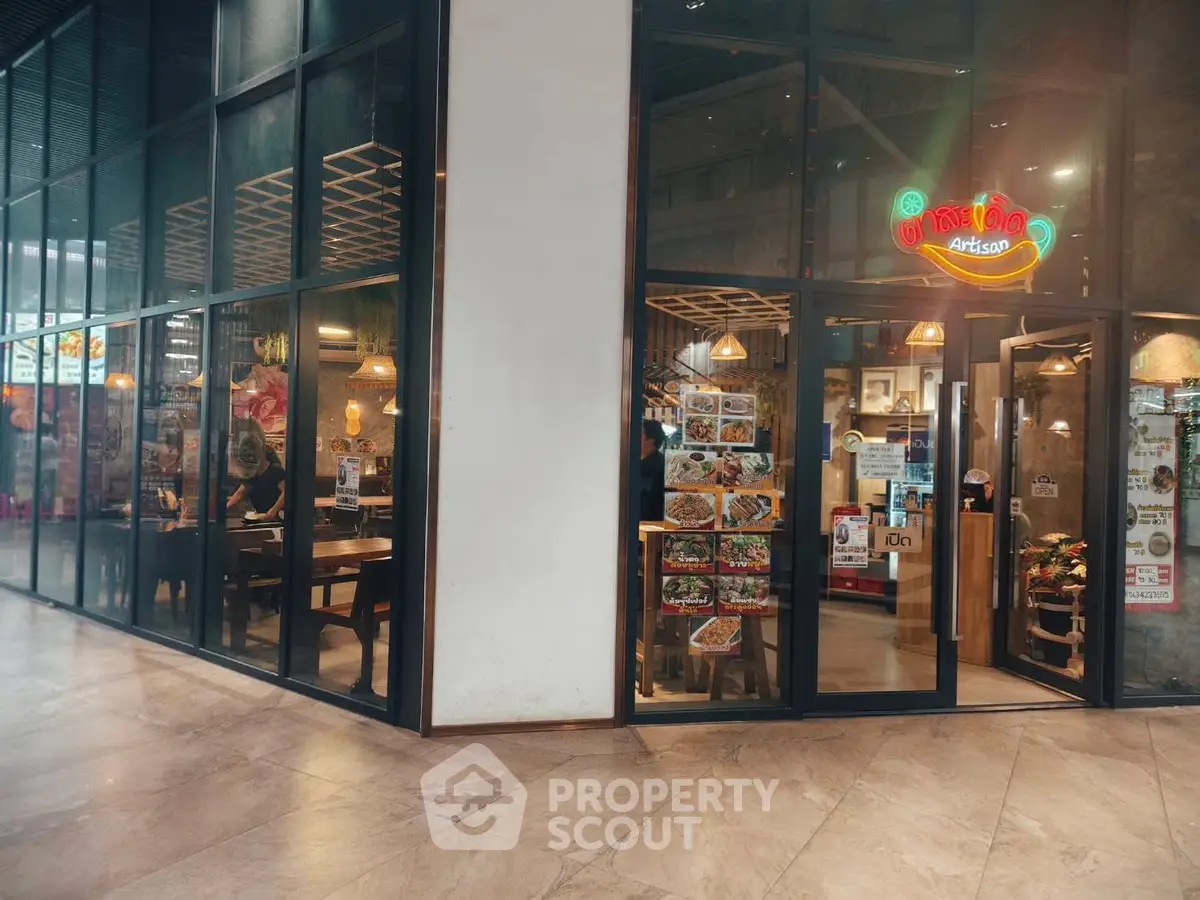 Modern commercial space with glass facade and inviting interior design in a bustling shopping area.