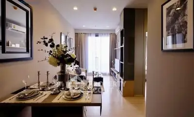 Stylish modern living room with elegant dining setup and natural light.