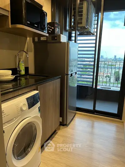 Modern kitchen with washing machine, fridge, and city view balcony