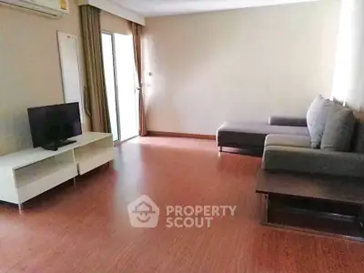 Spacious living room with modern sofa and flat-screen TV, perfect for relaxation.