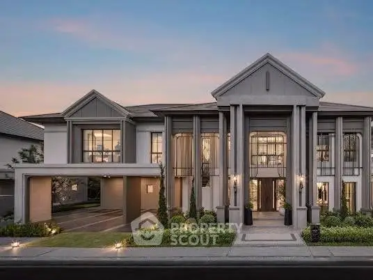 Luxurious modern mansion with grand entrance and elegant facade at sunset.