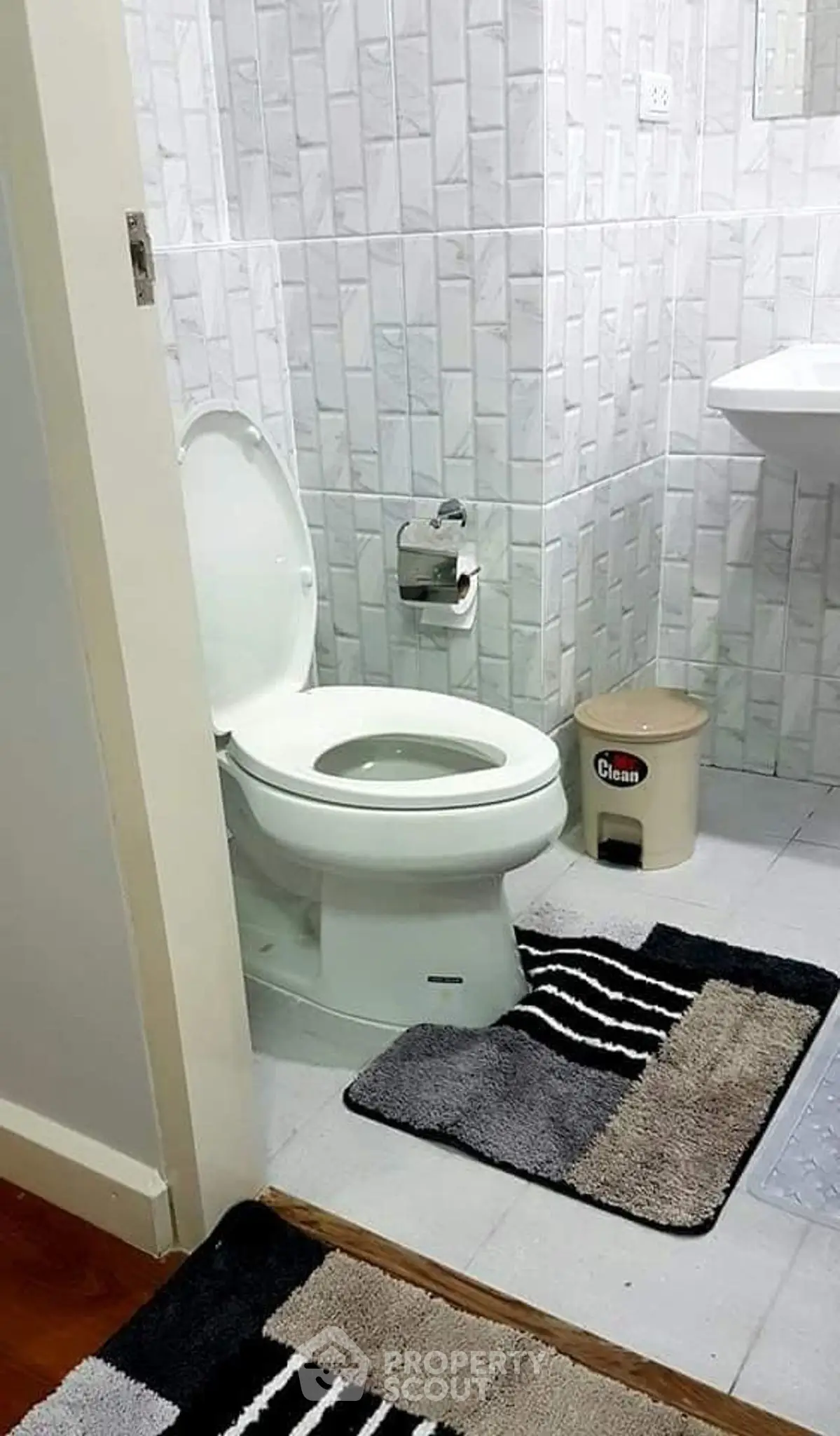 Modern bathroom with tiled walls and stylish rugs