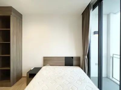 Modern bedroom with balcony access and sleek wooden furniture