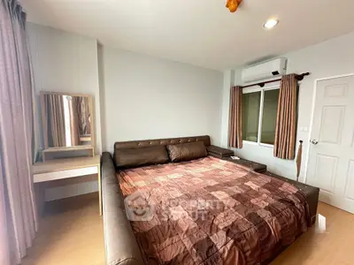 Spacious bedroom with cozy brown leather bed and modern decor