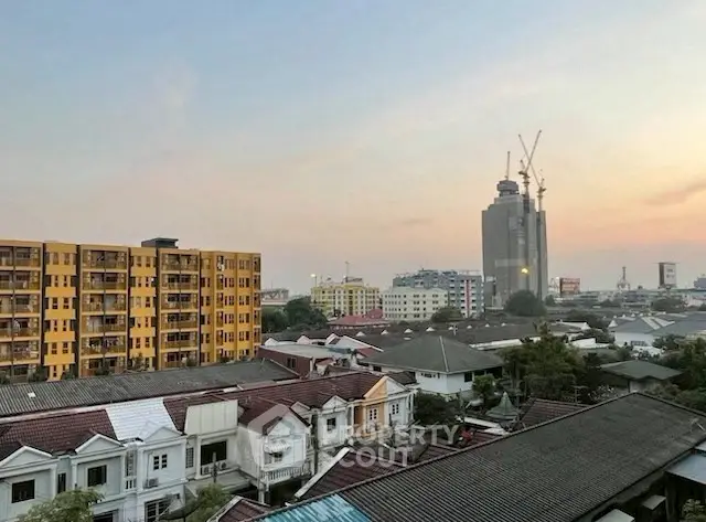 Stunning cityscape view with residential buildings and construction site at sunset.