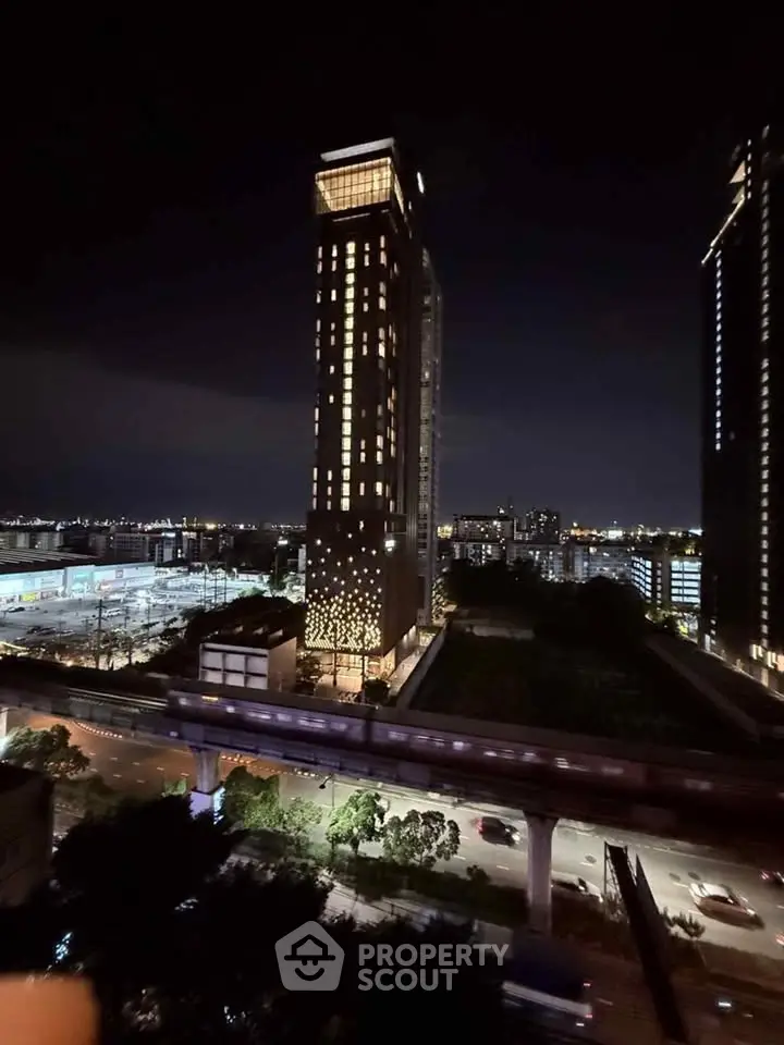 Stunning night view of a modern high-rise building with illuminated windows and cityscape backdrop.