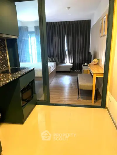 Modern studio apartment with sleek kitchen and cozy bedroom area