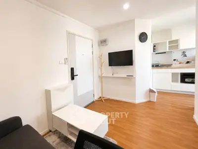 Modern living room with sleek white furniture and open kitchen layout