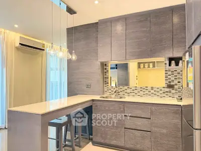 Modern kitchen with sleek cabinetry and stylish lighting in a contemporary apartment.