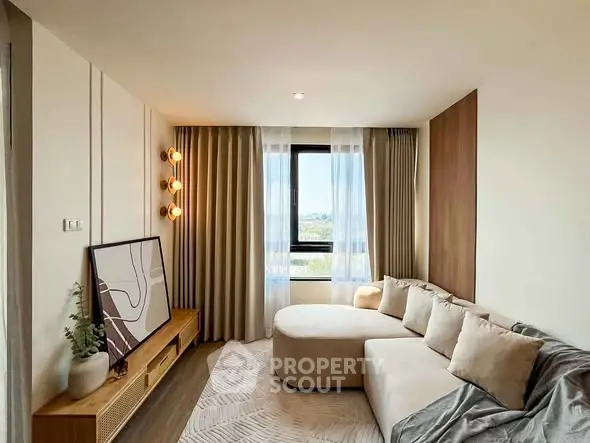 Modern living room with stylish decor and large window offering natural light and scenic view.