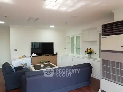 Spacious living room with modern furniture and large TV, perfect for relaxation.