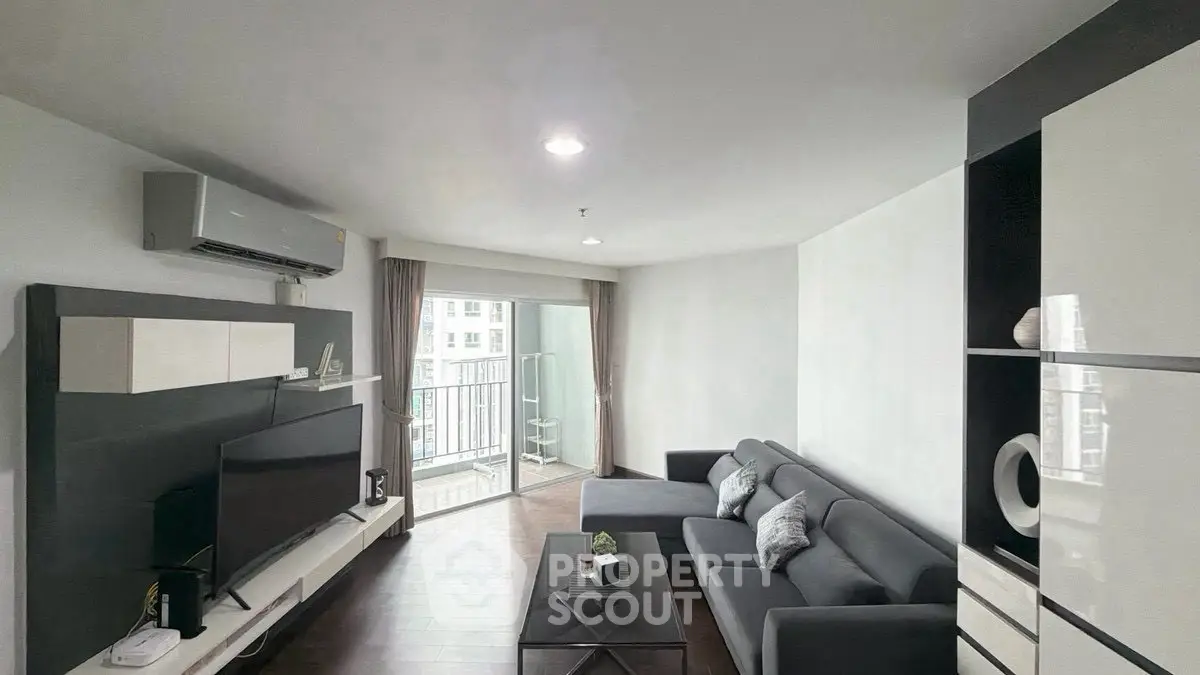 Modern living room with sleek furniture and balcony access in a stylish apartment.