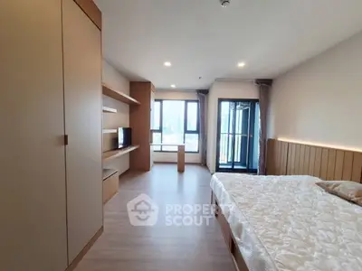 Spacious modern bedroom with balcony and built-in storage in a luxury apartment.