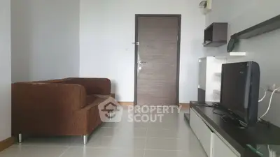 Modern living room with brown sofa and flat-screen TV, sleek design and neutral tones.