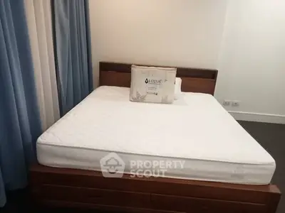 Spacious bedroom with elegant wooden bed and plush mattress in modern apartment.