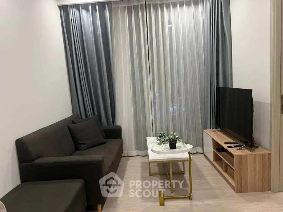 Modern living room with sleek furniture and large window drapes, perfect for cozy relaxation.