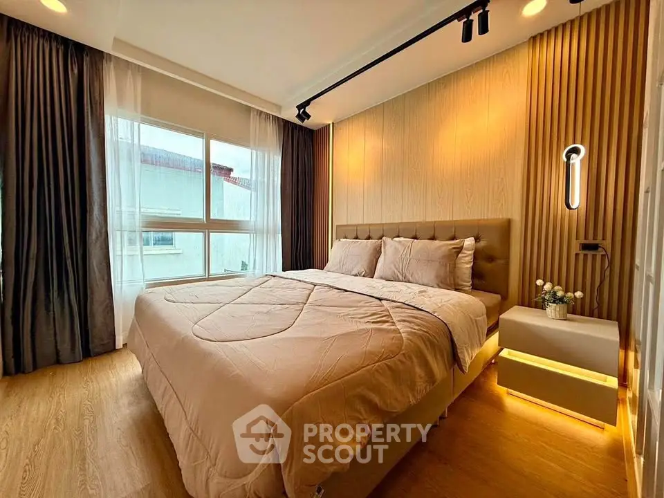 Luxurious bedroom with modern lighting and elegant decor, featuring a large window and cozy ambiance.
