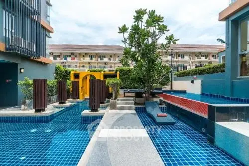 Luxurious modern pool area with unique design and lush greenery in a residential complex.