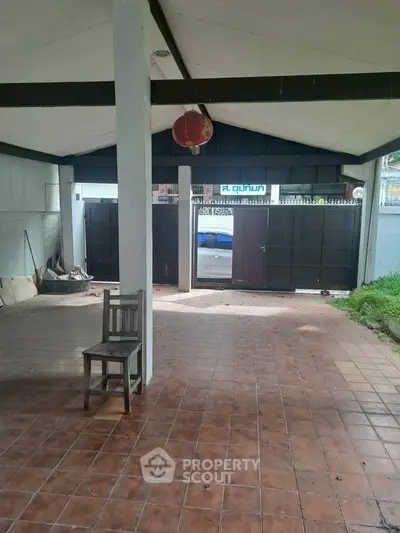 Spacious covered patio with tiled flooring and open view to garden area.