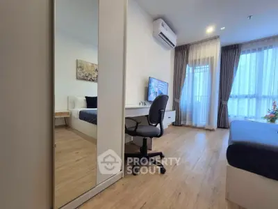 Modern bedroom with wooden flooring, large window, and stylish decor