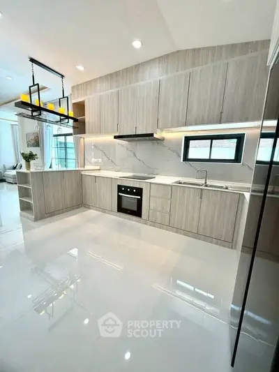 Modern kitchen with sleek cabinetry and built-in oven in a bright, open layout.